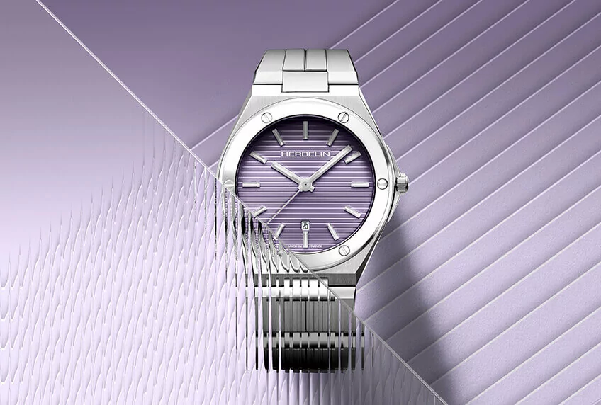 Ladies purple faced stainless steel wrist watch on a purple background.